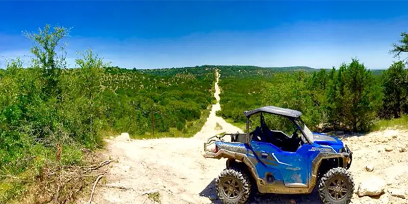 An ATV navigating a scenic, wooded trail at Hidden Falls Adventure Park.